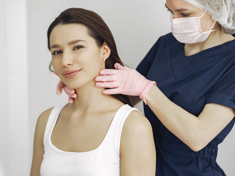 Ärztin kontrolliert die Haut einer Patientin