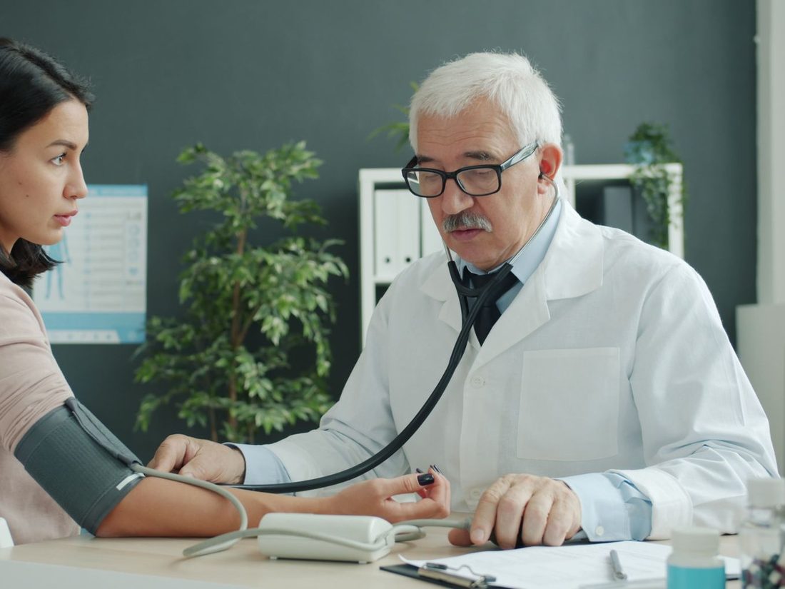 Arzt misst einer Patientin den Blutdruck