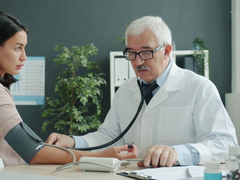 Arzt misst einer Patientin den Blutdruck
